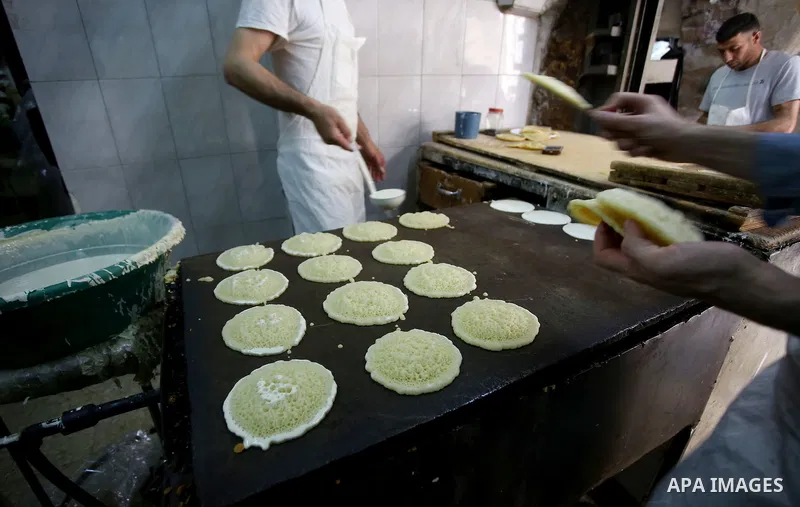 A Palestinian vendor prepares traditional pancakes known as ''Qatayef'' on the Muslim holy fasting month of Ramadan at his shop in the Old City of the West Bank town of Nablus on May 28, 2017. Ramadan is sacred to Muslim...
