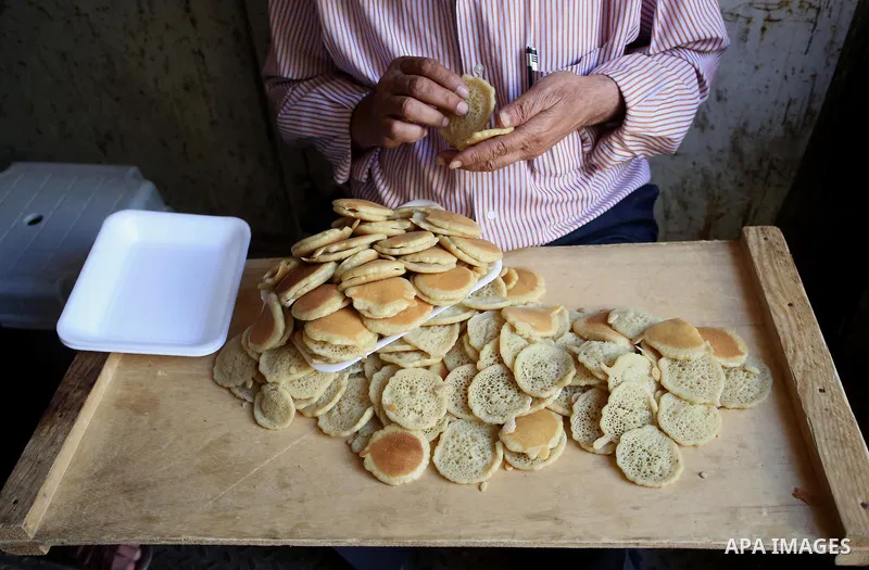 A Palestinian vendor sells traditional pancakes known as ''Qatayef'' on the Muslim holy fasting month of Ramadan at his shop in the Old City of the West Bank town of Nablus on May 28, 2017. Ramadan is sacred to Muslims b...