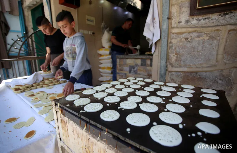 A Palestinian vendor prepares traditional pancakes known as ''Qatayef'' on the Muslim holy fasting month of Ramadan at his shop in the Old City of the West Bank town of Nablus on May 28, 2017. Ramadan is sacred to Muslim...