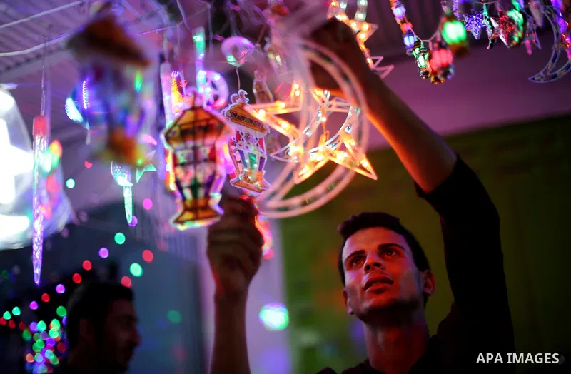 A Palestinian vendor decorates his shop with traditional lanterns known in Arabic as "Fanous" and festive lights on the Muslim holy fasting month of Ramadan on Gaza city on May 28, 2017. Ramadan is sacred to Muslims beca...