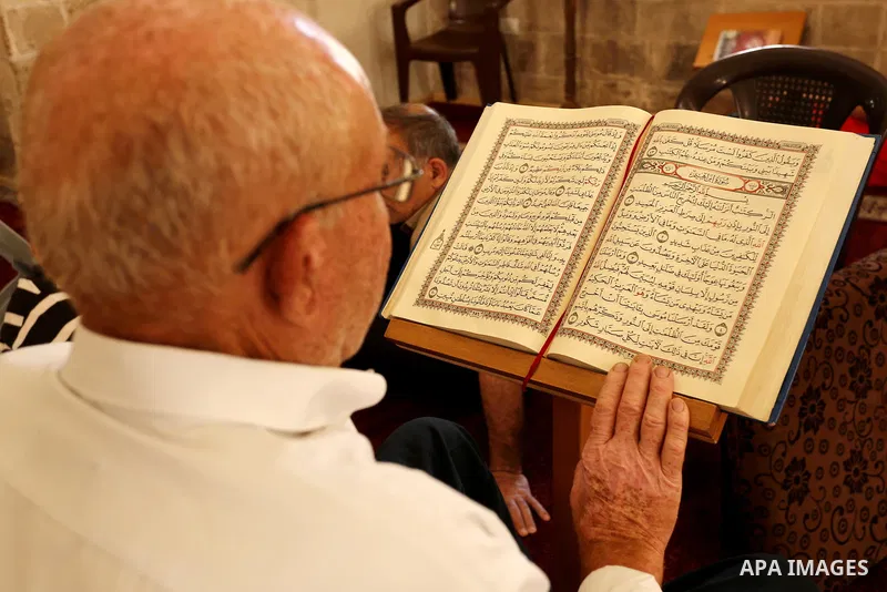 A Palestinian man reads a copy of the Koran, Islam's holiest book, on the Muslim holy fasting month of Ramadan at the al- Sayed Hashim mosque in Gaza city on May 29, 2017. Ramadan is sacred to Muslims because it is durin...