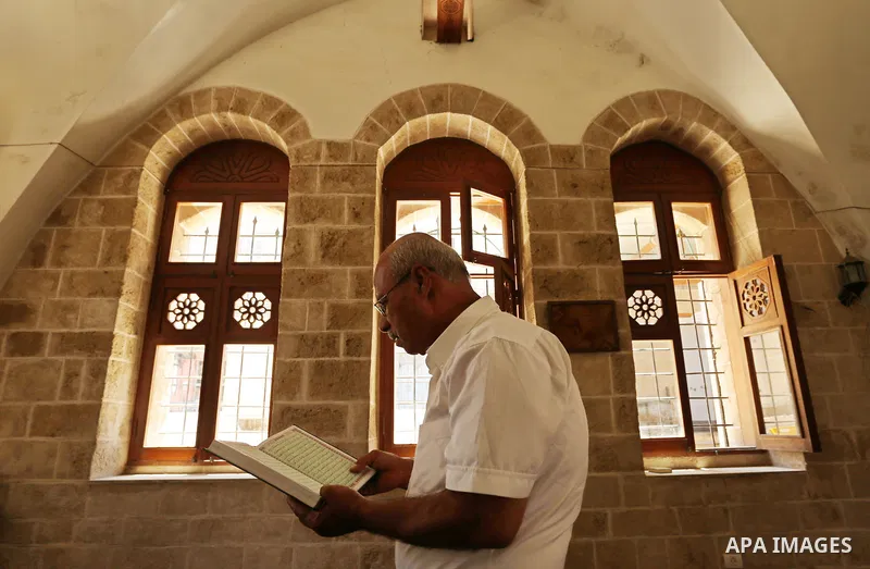 A Palestinian man reads a copy of the Koran, Islam's holiest book, on the Muslim holy fasting month of Ramadan at the al- Sayed Hashim mosque in Gaza city on May 29, 2017. Ramadan is sacred to Muslims because it is durin...