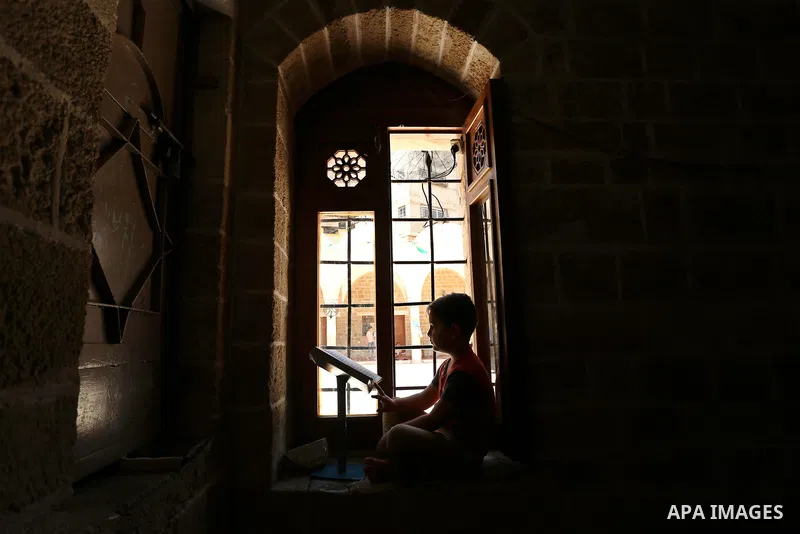 A Palestinian boy reads a copy of the Koran, Islam's holiest book, on the Muslim holy fasting month of Ramadan at the al- Sayed Hashim mosque in Gaza city on May 29, 2017. Ramadan is sacred to Muslims because it is durin...
