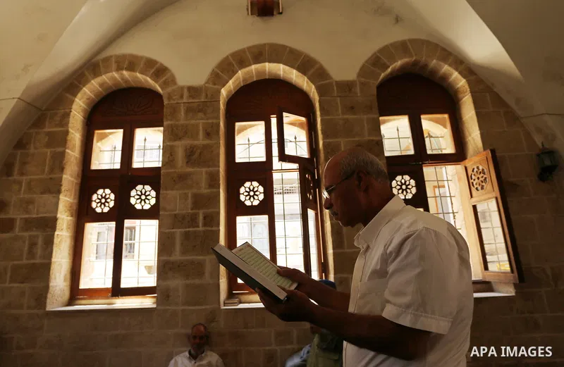 A Palestinian man reads a copy of the Koran, Islam's holiest book, on the Muslim holy fasting month of Ramadan at the al- Sayed Hashim mosque in Gaza city on May 29, 2017. Ramadan is sacred to Muslims because it is durin...