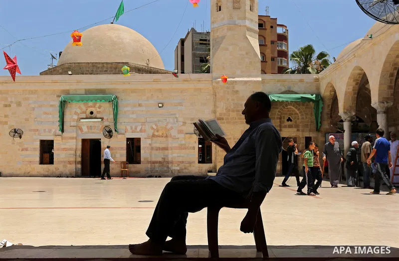 A Palestinian man reads a copy of the Koran, Islam's holiest book, on the Muslim holy fasting month of Ramadan at the al- Sayed Hashim mosque in Gaza city on May 29, 2017. Ramadan is sacred to Muslims because it is durin...