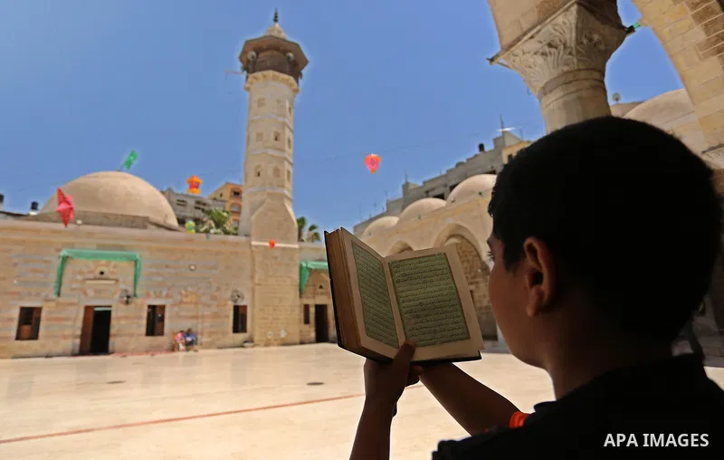 A Palestinian boy reads a copy of the Koran, Islam's holiest book, on the Muslim holy fasting month of Ramadan at the al- Sayed Hashim mosque in Gaza city on May 29, 2017. Ramadan is sacred to Muslims because it is durin...
