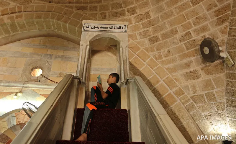 A Palestinian boy reads a copy of the Koran, Islam's holiest book, on the Muslim holy fasting month of Ramadan at the al- Sayed Hashim mosque in Gaza city on May 29, 2017. Ramadan is sacred to Muslims because it is durin...