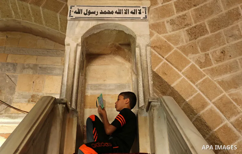 A Palestinian boy reads a copy of the Koran, Islam's holiest book, on the Muslim holy fasting month of Ramadan at the al- Sayed Hashim mosque in Gaza city on May 29, 2017. Ramadan is sacred to Muslims because it is durin...