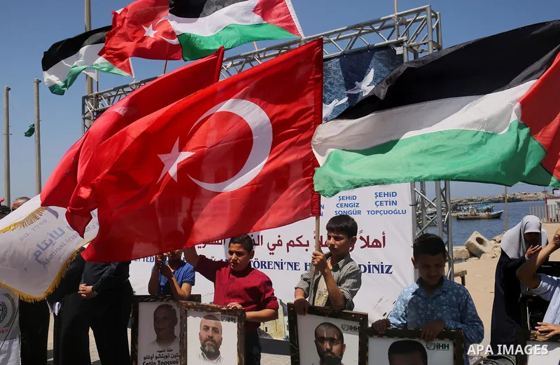 Palestinian children hold the Palestinian and Turkish flags and picture of activists who was dead by Israeli forces during a rally to mark the 7th anniversary of the Mavi Marmara Gaza flotilla incident, at the seaport of...