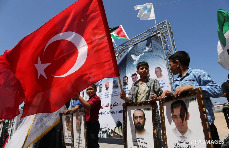 Palestinian children hold the Palestinian and Turkish flags and picture of activists who was dead by Israeli forces during a rally to mark the 7th anniversary of the Mavi Marmara Gaza flotilla incident, at the seaport of...