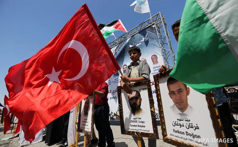 Palestinian children hold the Palestinian and Turkish flags and picture of activists who was dead by Israeli forces during a rally to mark the 7th anniversary of the Mavi Marmara Gaza flotilla incident, at the seaport of...