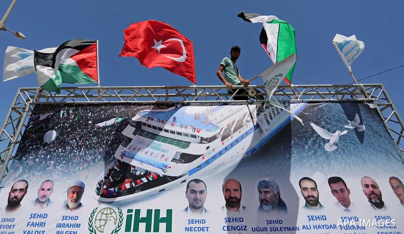A Palestinian man holds Palestinian and Turkish flags during a rally to mark the 7th anniversary of the Mavi Marmara Gaza flotilla incident, at the seaport of Gaza City May 31, 2017. Nine activists, eight Turkish and one...