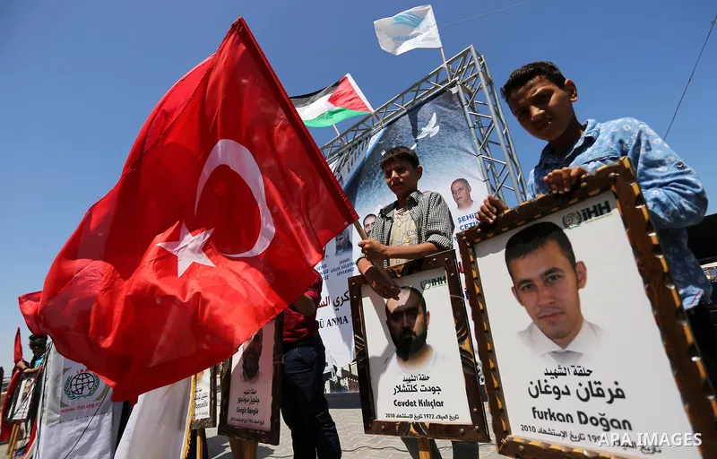 Palestinian children hold the Palestinian and Turkish flags and picture of activists who was dead by Israeli forces during a rally to mark the 7th anniversary of the Mavi Marmara Gaza flotilla incident, at the seaport of...