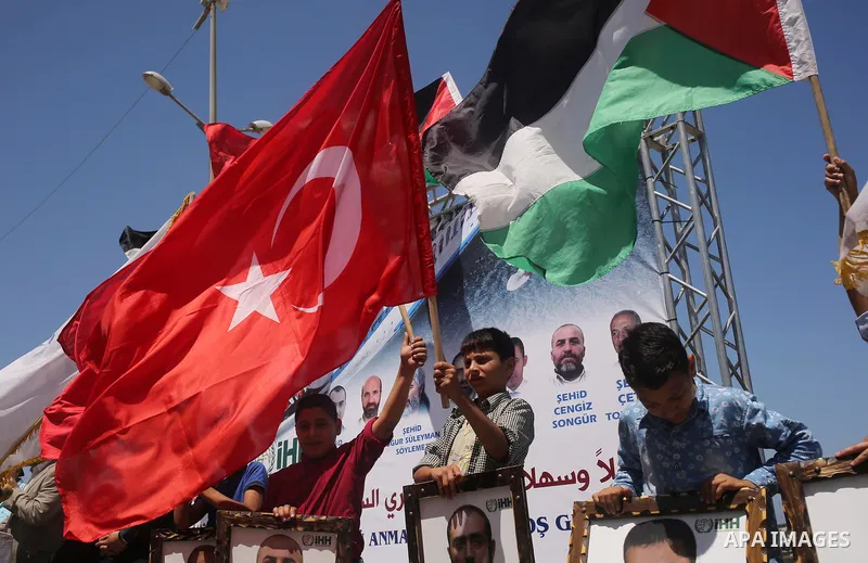 Palestinian children hold the Palestinian and Turkish flags and picture of activists who was dead by Israeli forces during a rally to mark the 7th anniversary of the Mavi Marmara Gaza flotilla incident, at the seaport of...