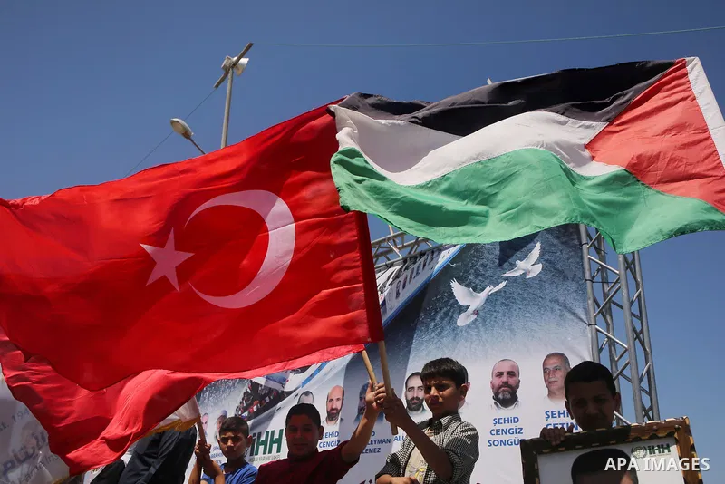 Palestinian children hold the Palestinian and Turkish flags and picture of activists who was dead by Israeli forces during a rally to mark the 7th anniversary of the Mavi Marmara Gaza flotilla incident, at the seaport of...