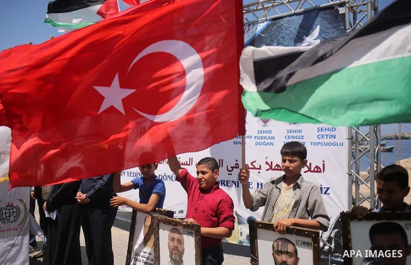 Palestinian children hold the Palestinian and Turkish flags and picture of activists who was dead by Israeli forces during a rally to mark the 7th anniversary of the Mavi Marmara Gaza flotilla incident, at the seaport of...