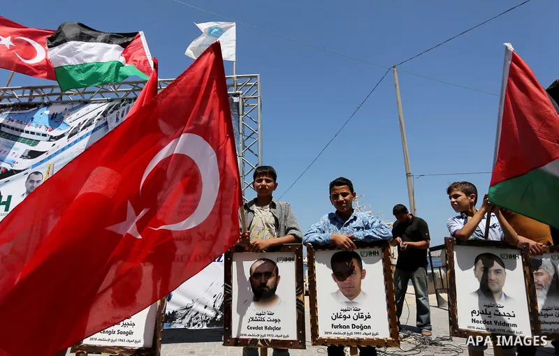 Palestinian children hold the Palestinian and Turkish flags and picture of activists who was dead by Israeli forces during a rally to mark the 7th anniversary of the Mavi Marmara Gaza flotilla incident, at the seaport of...