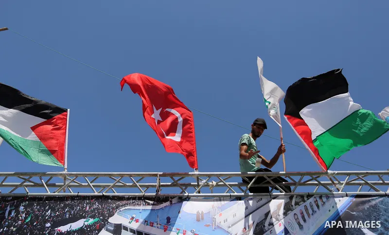 A Palestinian man holds Palestinian and Turkish flags during a rally to mark the 7th anniversary of the Mavi Marmara Gaza flotilla incident, at the seaport of Gaza City May 31, 2017. Nine activists, eight Turkish and one...