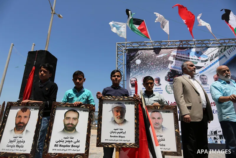 Palestinian children hold the Palestinian and Turkish flags and picture of activists who was dead by Israeli forces during a rally to mark the 7th anniversary of the Mavi Marmara Gaza flotilla incident, at the seaport of...