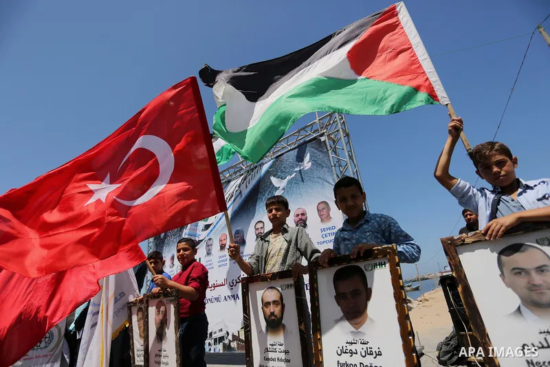 Palestinian children hold the Palestinian and Turkish flags and picture of activists who was dead by Israeli forces during a rally to mark the 7th anniversary of the Mavi Marmara Gaza flotilla incident, at the seaport of...
