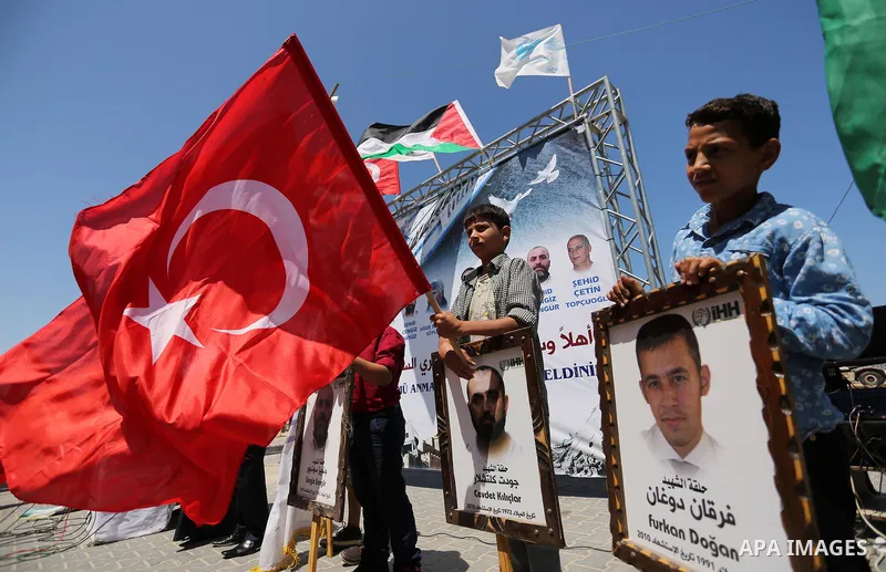 Palestinian children hold the Palestinian and Turkish flags and picture of activists who was dead by Israeli forces during a rally to mark the 7th anniversary of the Mavi Marmara Gaza flotilla incident, at the seaport of...