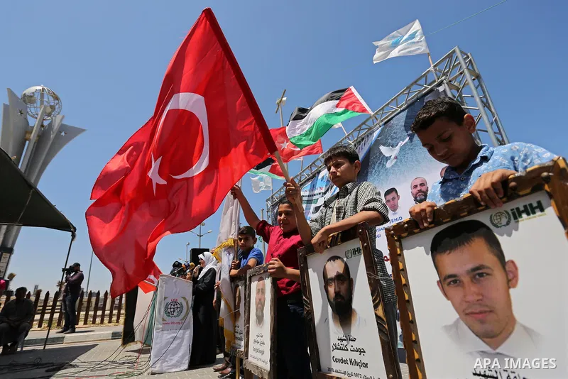 Palestinian children hold the Palestinian and Turkish flags and picture of activists who was dead by Israeli forces during a rally to mark the 7th anniversary of the Mavi Marmara Gaza flotilla incident, at the seaport of...