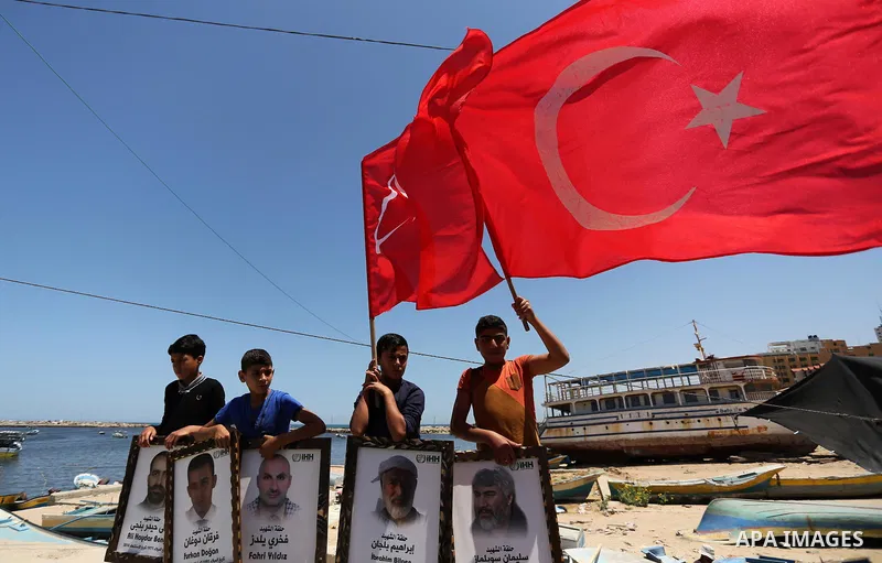 Palestinian children hold Turkish flags and picture of activists who was dead by Israeli forces during a rally to mark the 7th anniversary of the Mavi Marmara Gaza flotilla incident, at the seaport of Gaza City May 31, 2...