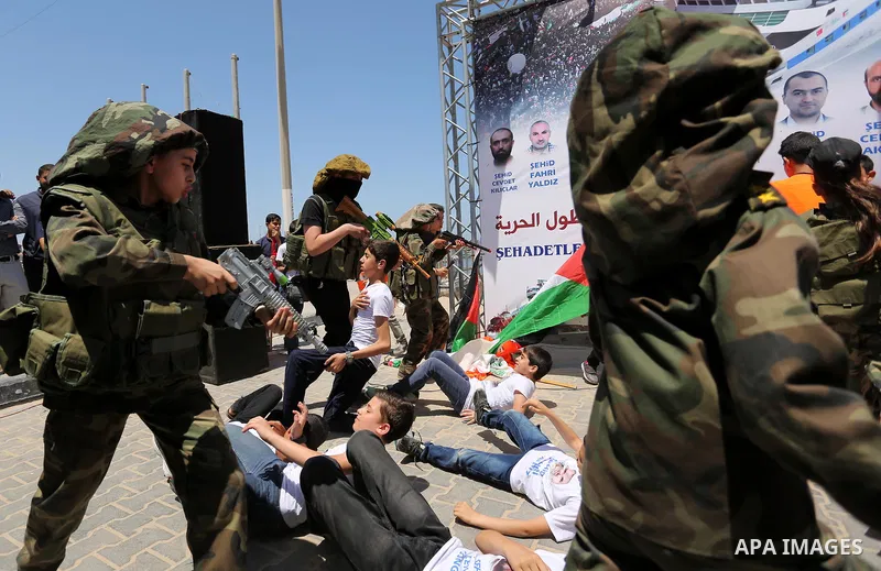 Palestinian children take part during a rally to mark the 7th anniversary of the Mavi Marmara Gaza flotilla incident, as they simulate the raided of Israeli commandos to Mavi Marmara ship, at the seaport of Gaza City May...