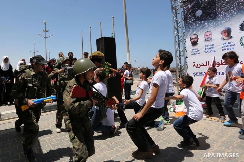 Palestinian children take part during a rally to mark the 7th anniversary of the Mavi Marmara Gaza flotilla incident, as they simulate the raided of Israeli commandos to Mavi Marmara ship, at the seaport of Gaza City May...