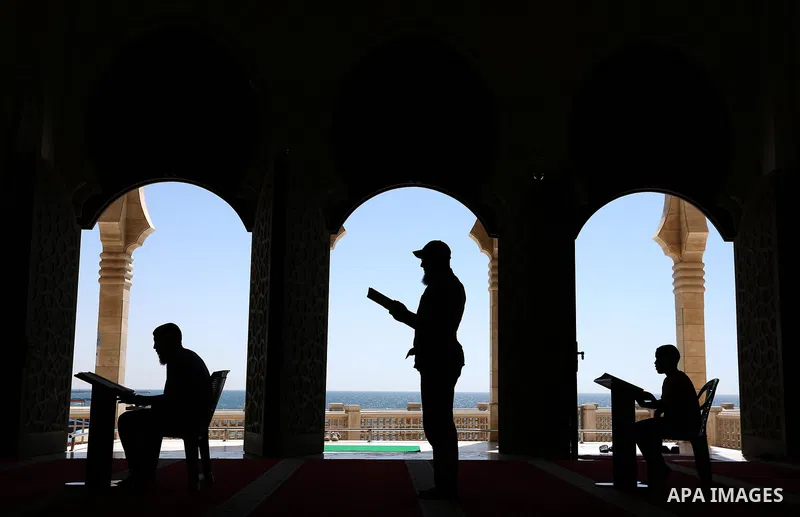 Palestinians read a copy of the Koran, Islam's holiest book, on the Muslim holy fasting month of Ramadan at al-Khaldi mosque in Gaza city on May 31, 2017. Ramadan is sacred to Muslims because it is during that month that...