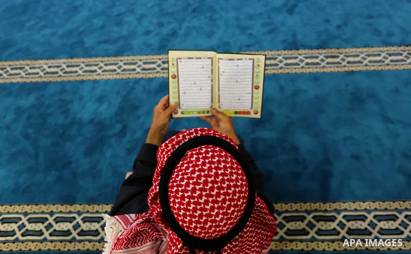 A Palestinian man reads a copy of the Koran, Islam's holiest book, on the Muslim holy fasting month of Ramadan at the al-Omari mosque in Gaza city on May 31, 2017. Ramadan is sacred to Muslims because it is during that m...