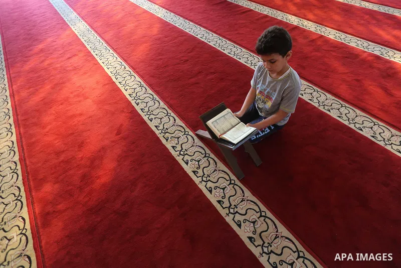 A Palestinian boy reads a copy of the Koran, Islam's holiest book, on the Muslim holy fasting month of Ramadan at al-Khaldi mosque in Gaza city on May 31, 2017. Ramadan is sacred to Muslims because it is during that mont...