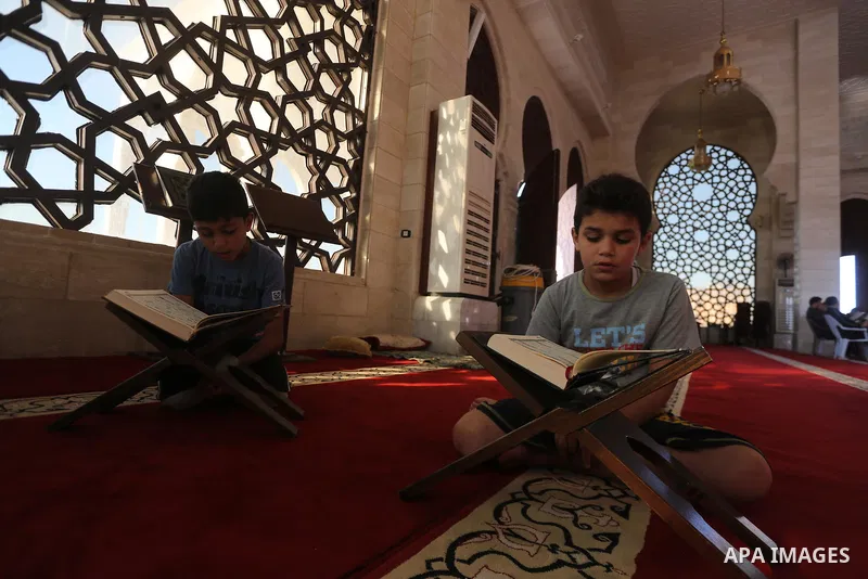 Palestinian boys read a copy of the Koran, Islam's holiest book, on the Muslim holy fasting month of Ramadan at al-Khaldi mosque in Gaza city on May 31, 2017. Ramadan is sacred to Muslims because it is during that month...