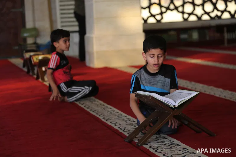 Palestinian boys read a copy of the Koran, Islam's holiest book, on the Muslim holy fasting month of Ramadan at al-Khaldi mosque in Gaza city on May 31, 2017. Ramadan is sacred to Muslims because it is during that month...