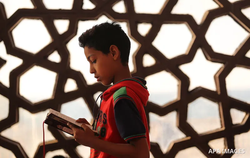 A Palestinian boy reads a copy of the Koran, Islam's holiest book, on the Muslim holy fasting month of Ramadan at al-Khaldi mosque in Gaza city on May 31, 2017. Ramadan is sacred to Muslims because it is during that mont...