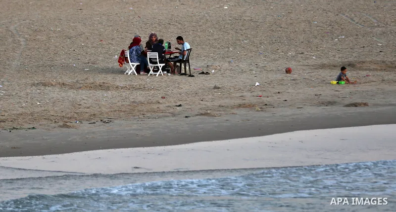 A Palestinian family gathers at the beach, during power cuts, to break their fast in Gaza City on May 31, 2017, during the Muslim Holy month of Ramadan. Ramadan is sacred to Muslims because it is during that month that t...