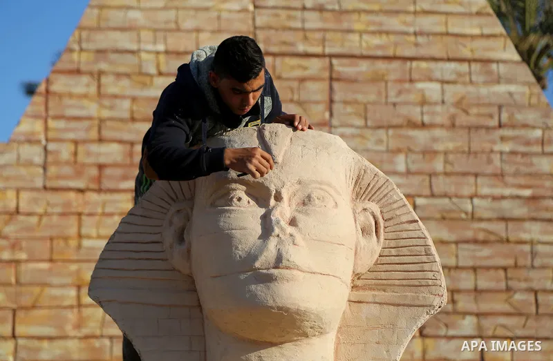 A Palestinian artist works on a wooden sculpture of sphinx at a technical site in the southern Gaza Strip town of Rafah, near the border with Egypt, on June 1, 2017. Young artists Palestinian artists Nidal Al-Jarami and...