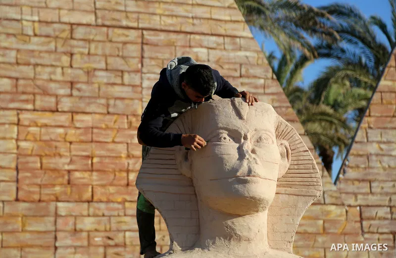 A Palestinian artist works on a wooden sculpture of sphinx at a technical site in the southern Gaza Strip town of Rafah, near the border with Egypt, on June 1, 2017. Young artists Palestinian artists Nidal Al-Jarami and...