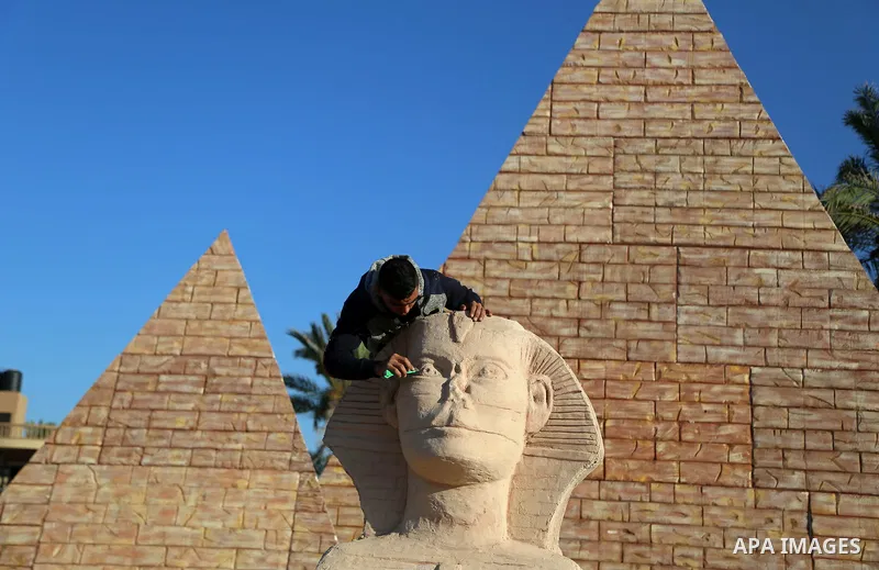 A Palestinian artist works on a wooden sculpture of sphinx at a technical site in the southern Gaza Strip town of Rafah, near the border with Egypt, on June 1, 2017. Young artists Palestinian artists Nidal Al-Jarami and...
