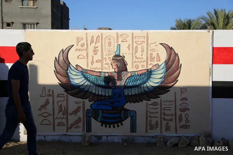 A Palestinian man walks past a mural drawings of Pharaonic figure at a technical site in the southern Gaza Strip town of Rafah, near the border with Egypt, on June 1, 2017. Young artists Palestinian artists Nidal Al-Jara...