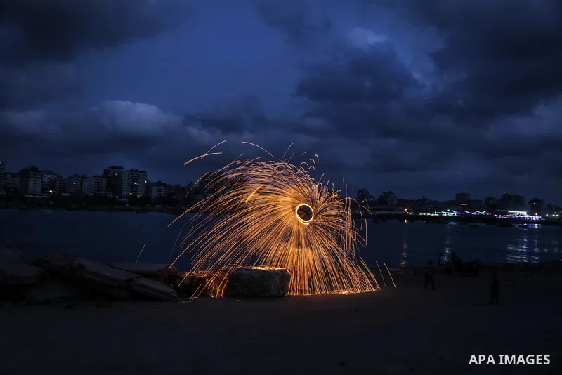 A Palestinian man plays with fire crackers celebrating on the holy month of Ramadan at the seaport of Gaza city, on June 1, 2017. Ramadan is sacred to Muslims because it is during that month that tradition says the Koran...