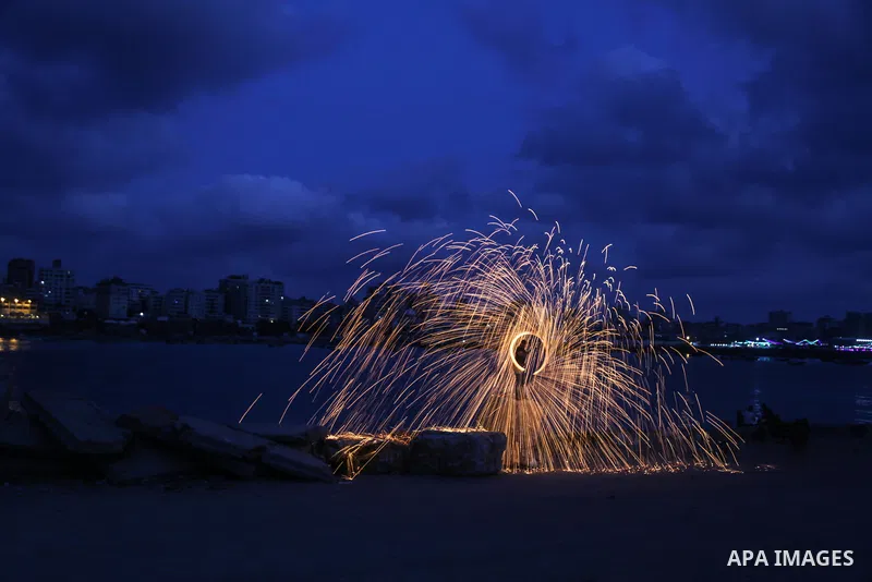 A Palestinian man plays with fire crackers celebrating on the holy month of Ramadan at the seaport of Gaza city, on June 1, 2017. Ramadan is sacred to Muslims because it is during that month that tradition says the Koran...