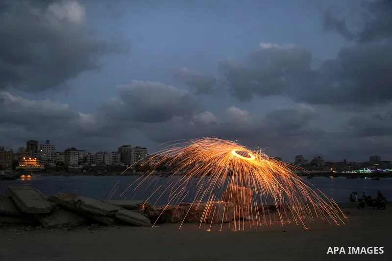 A Palestinian man plays with fire crackers celebrating on the holy month of Ramadan at the seaport of Gaza city, on June 1, 2017. Ramadan is sacred to Muslims because it is during that month that tradition says the Koran...