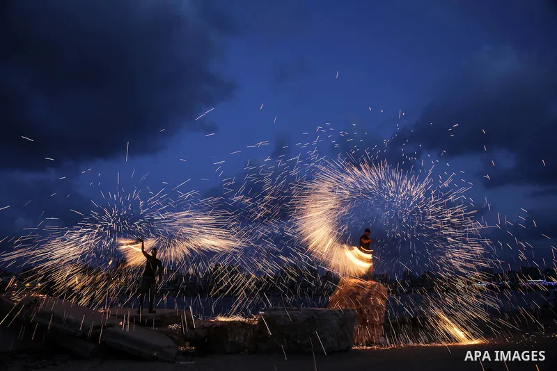A Palestinian man plays with fire crackers celebrating on the holy month of Ramadan at the seaport of Gaza city, on June 1, 2017. Ramadan is sacred to Muslims because it is during that month that tradition says the Koran...