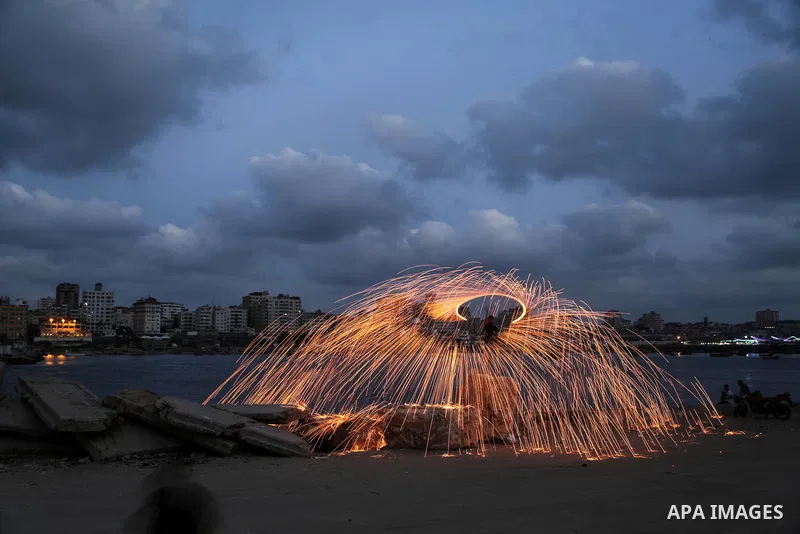 A Palestinian man plays with fire crackers celebrating on the holy month of Ramadan at the seaport of Gaza city, on June 1, 2017. Ramadan is sacred to Muslims because it is during that month that tradition says the Koran...