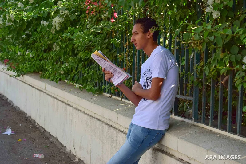 An Egyptian student stands outside his school in the first day of high school exams, in Cairo, Egypt, on June 04, 2017. Photo by Amr Sayed