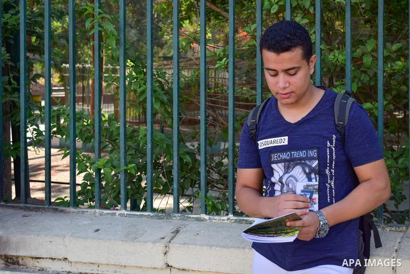 An Egyptian student stands outside his school in the first day of high school exams, in Cairo, Egypt, on June 04, 2017. Photo by Amr Sayed