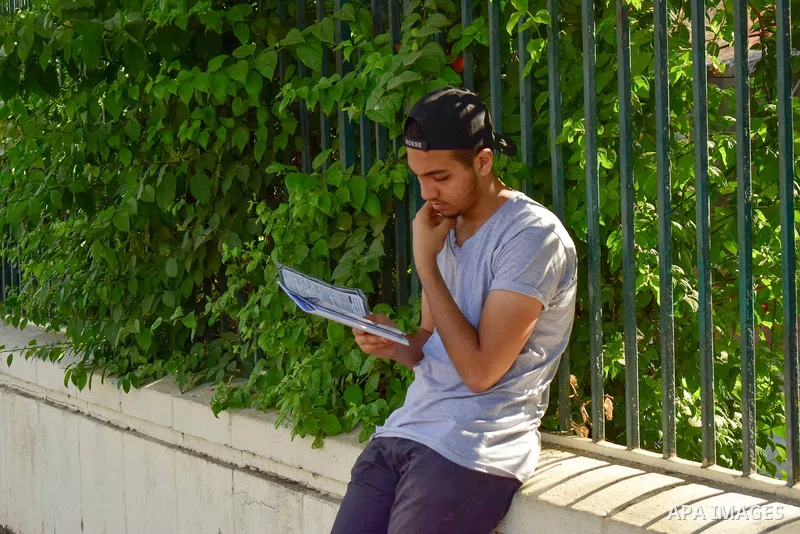 An Egyptian student stands outside his school in the first day of high school exams, in Cairo, Egypt, on June 04, 2017. Photo by Amr Sayed