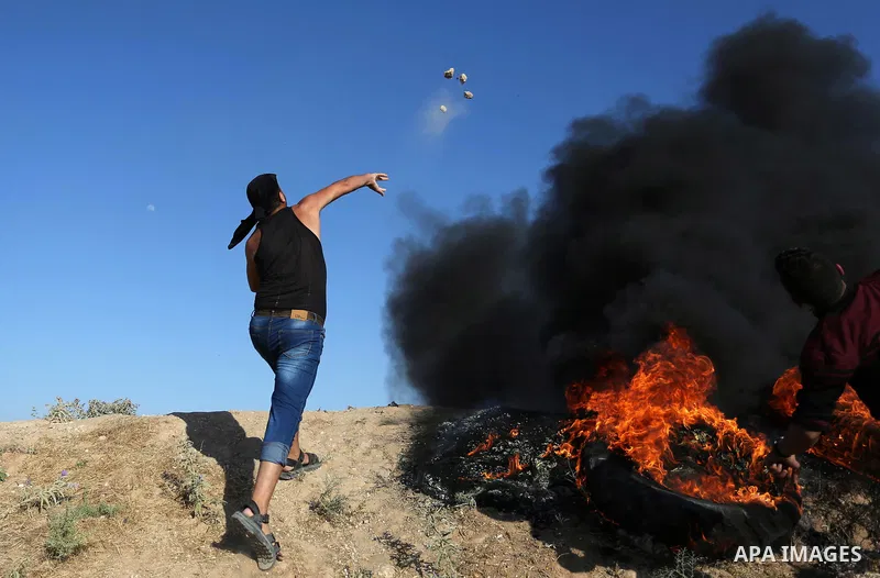 A Palestinian protester hurls stones towards Israeli security forces during clashes following a demonstration against the blockade on the Gaza Strip, near the border fence east of Jabalia refugee camp on June 5, 2017. Ph...