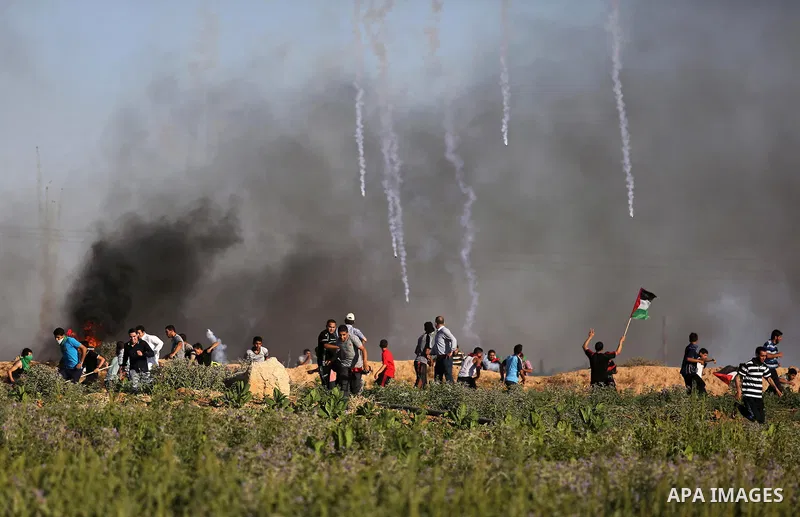 Palestinian protesters take cover during clashes with Israeli security forces following a demonstration against the blockade on the Gaza Strip, near the border fence east of Jabalia refugee camp on June 5, 2017. Photo by...